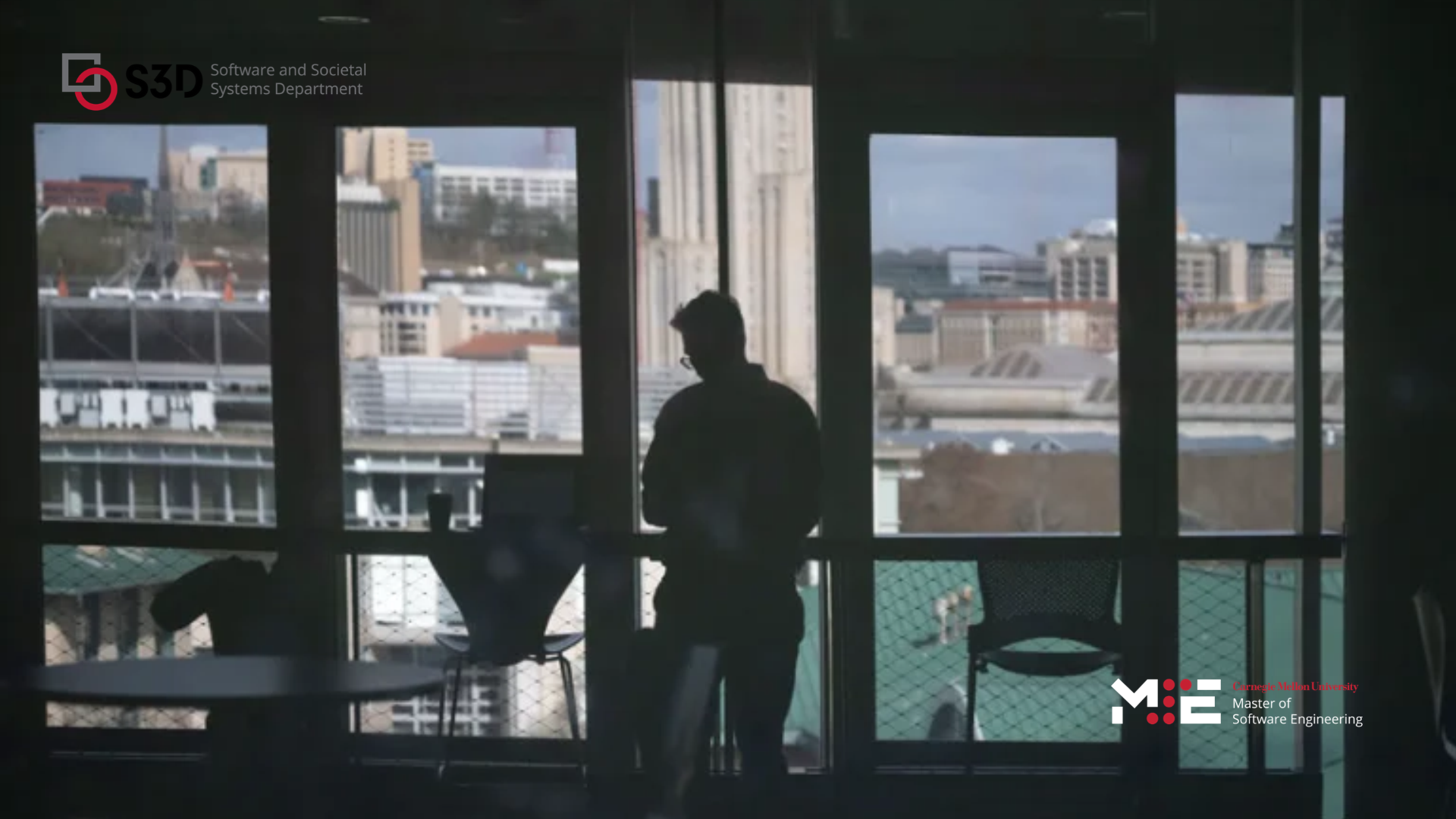 a figure in shadow stands in front of windows